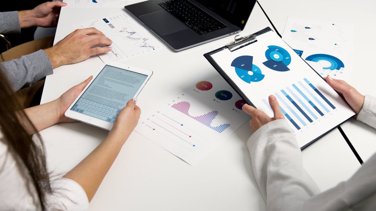 about-us-01 Team analyzing financial charts and digital reports during a business meeting.